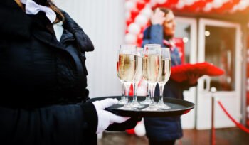 waiter-with-tray-champagne-glasses-official-opening-350x204